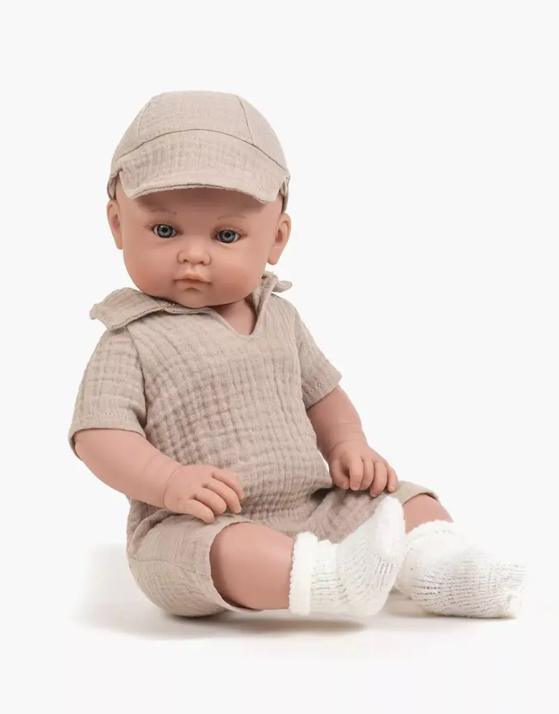 minikane-vetements-poupees-bambinis-47cm-yann-habille-de-son-ensemble-combinaison-tom-et-casquette-en-double-gaze-beige-assis.webp